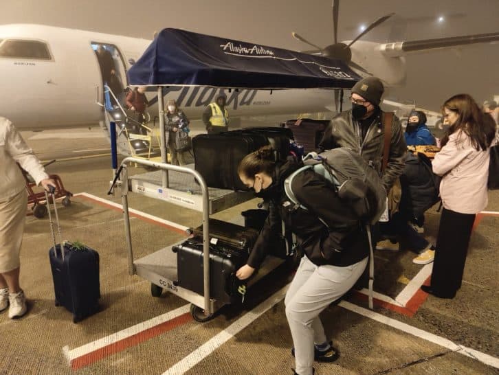 a group of people with luggage in a tarmac