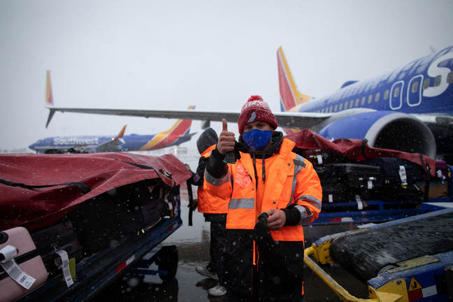 a person wearing a face mask and standing next to airplanes
