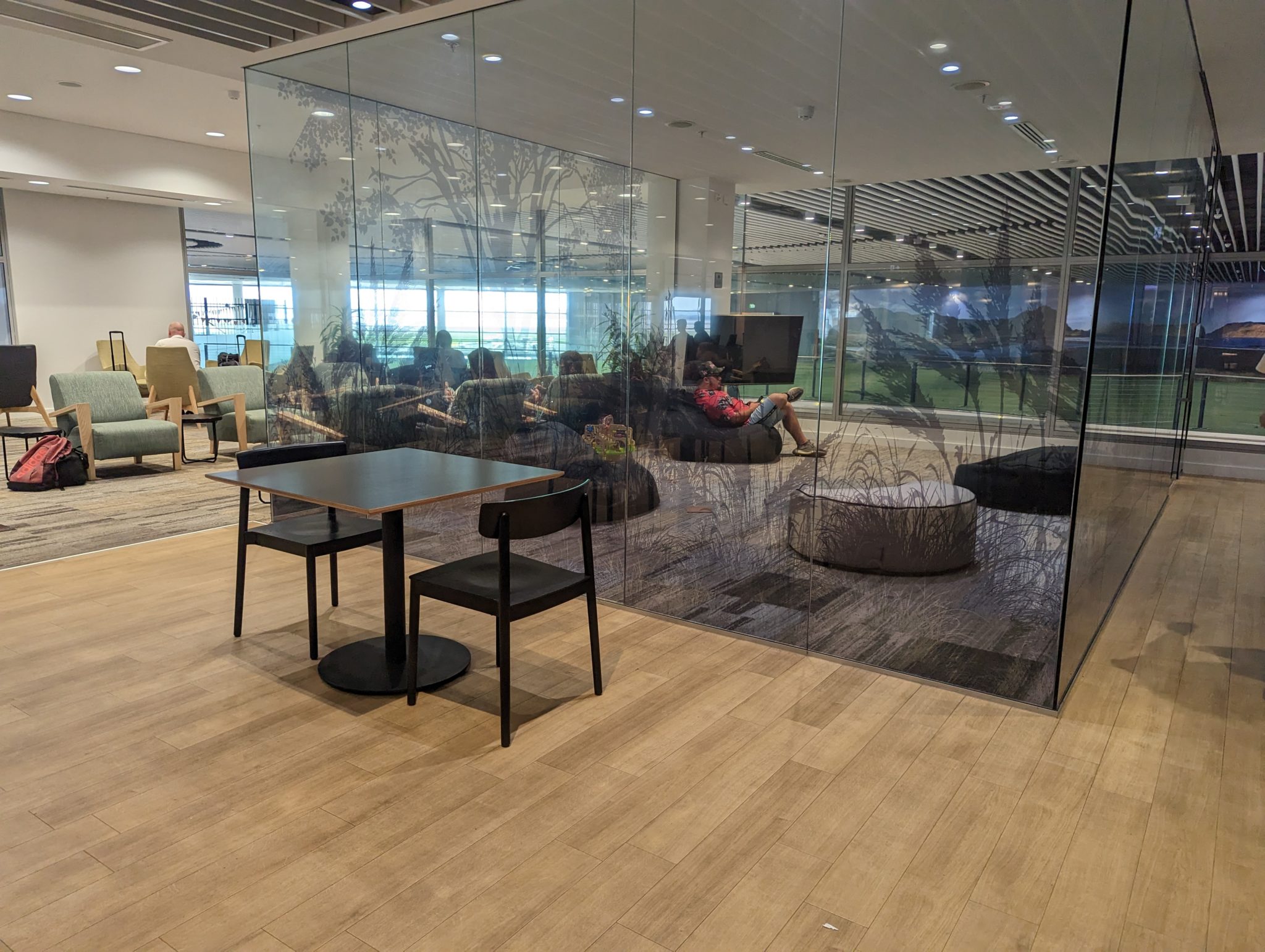 a glass wall with people sitting on it