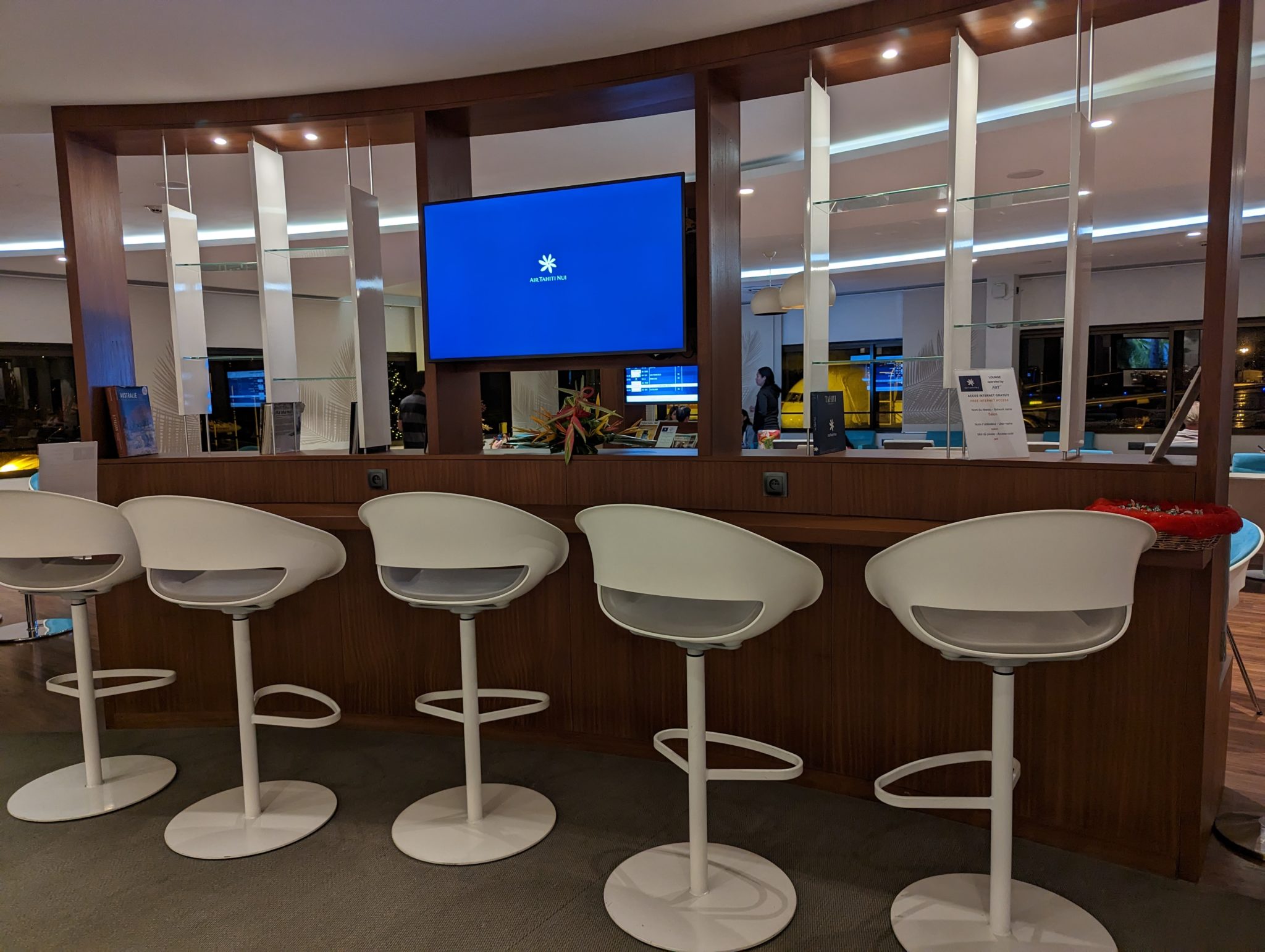 a row of white chairs in a room with a television