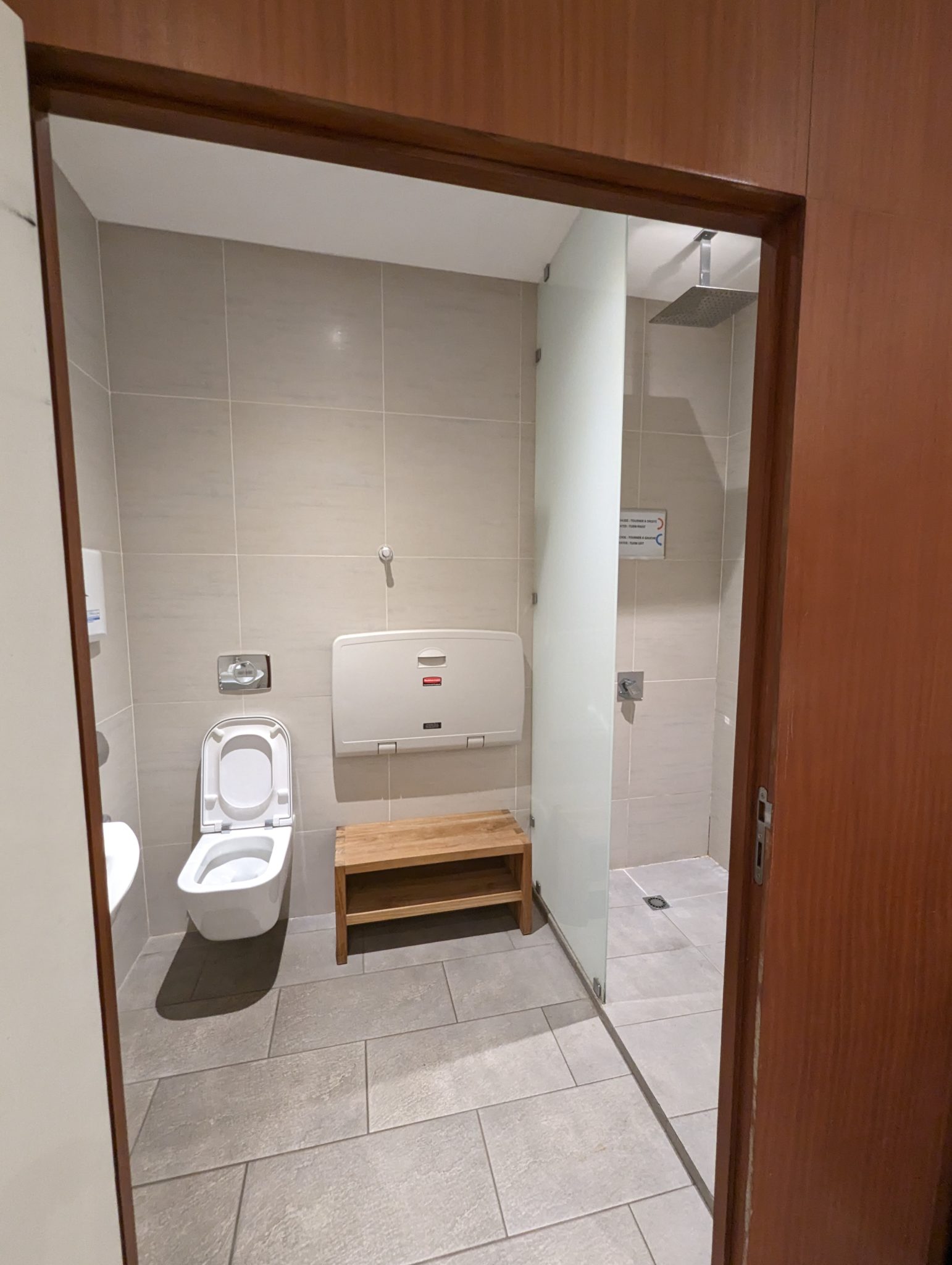 a bathroom with a toilet and a wood door