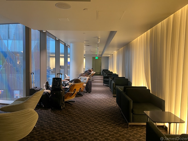 a group of people sitting in chairs in a room with windows