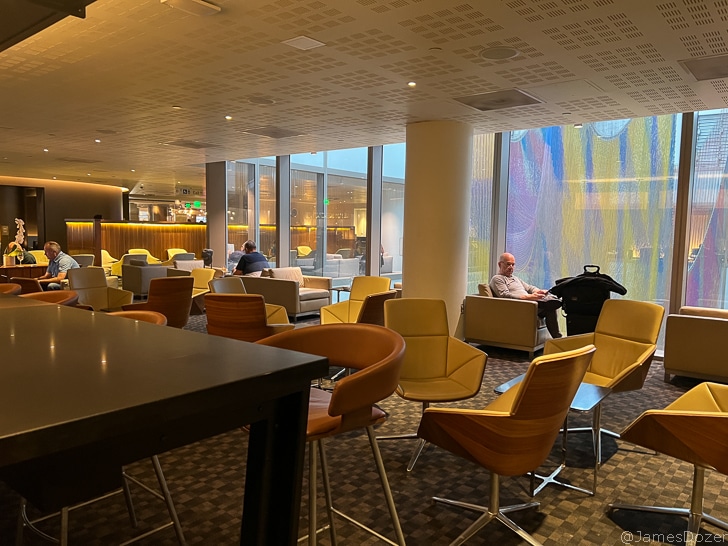 a group of people sitting in a room with chairs and tables