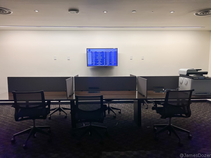 a room with a table and chairs and a monitor