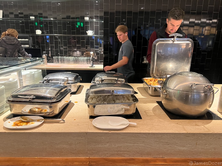 a group of people standing next to a buffet table