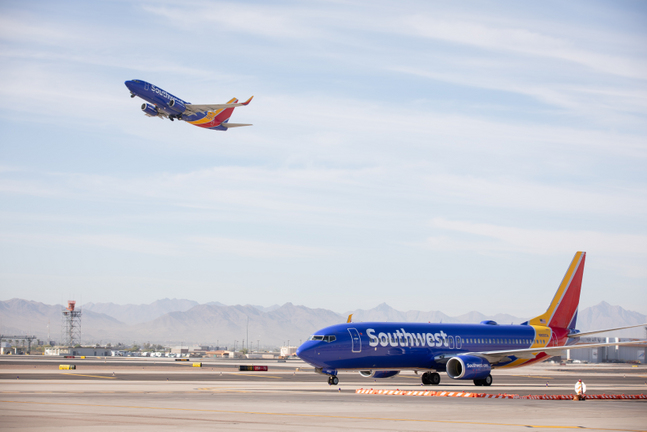 a blue and yellow airplane on a runway