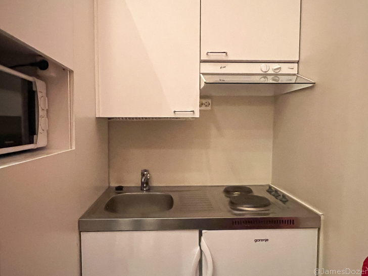 a small kitchen with white cabinets and a sink
