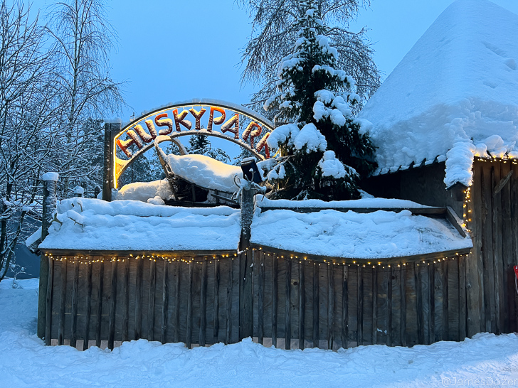 a sign on a fence with snow on it