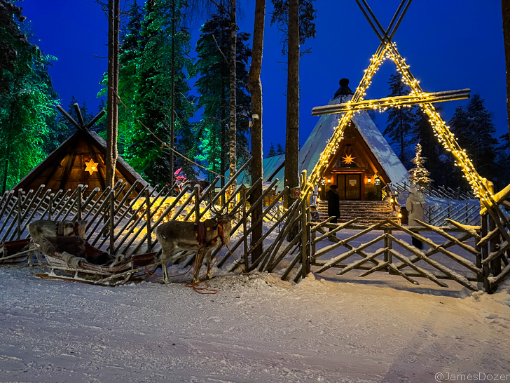 a group of reindeer in a sleigh in front of a building