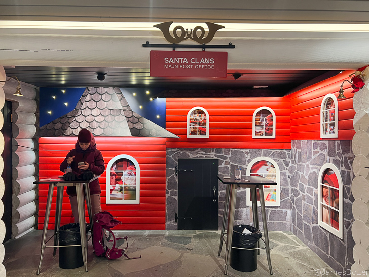 a person standing at a table in front of a red and white building