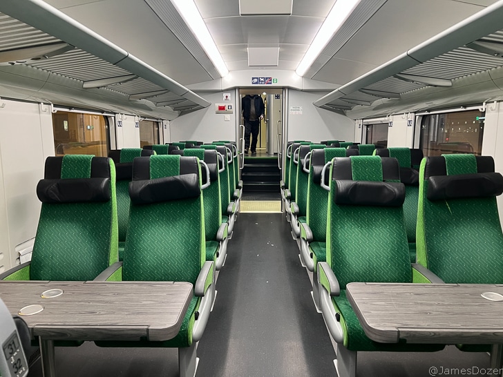 a green and black seats in a train