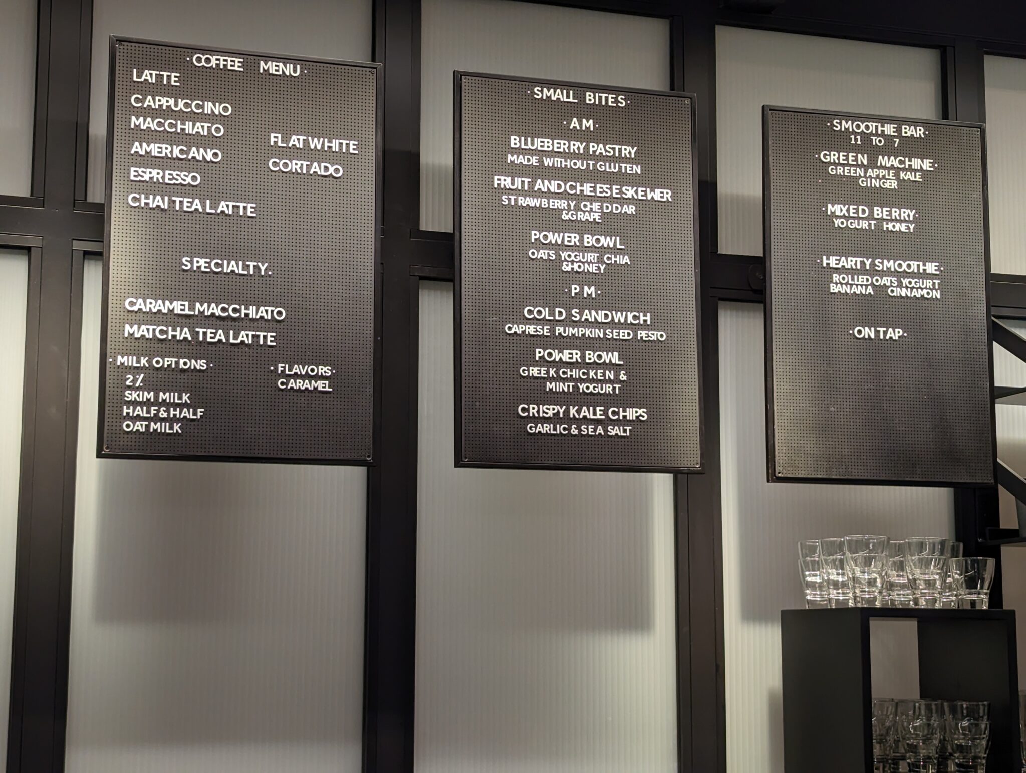 a menu board with white text on a black wall
