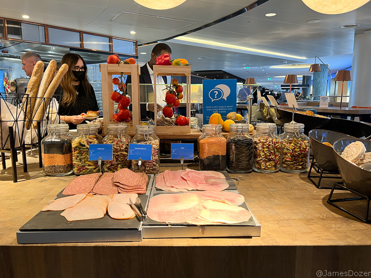 a food buffet with a woman behind it