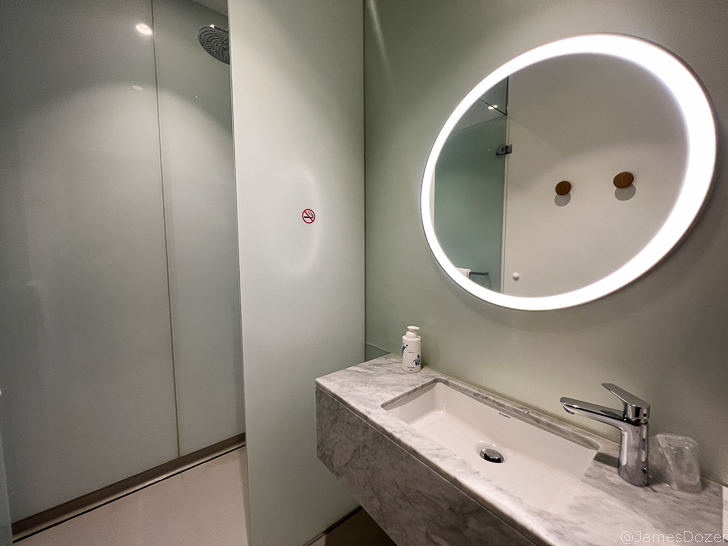 a bathroom with a round mirror and a shower