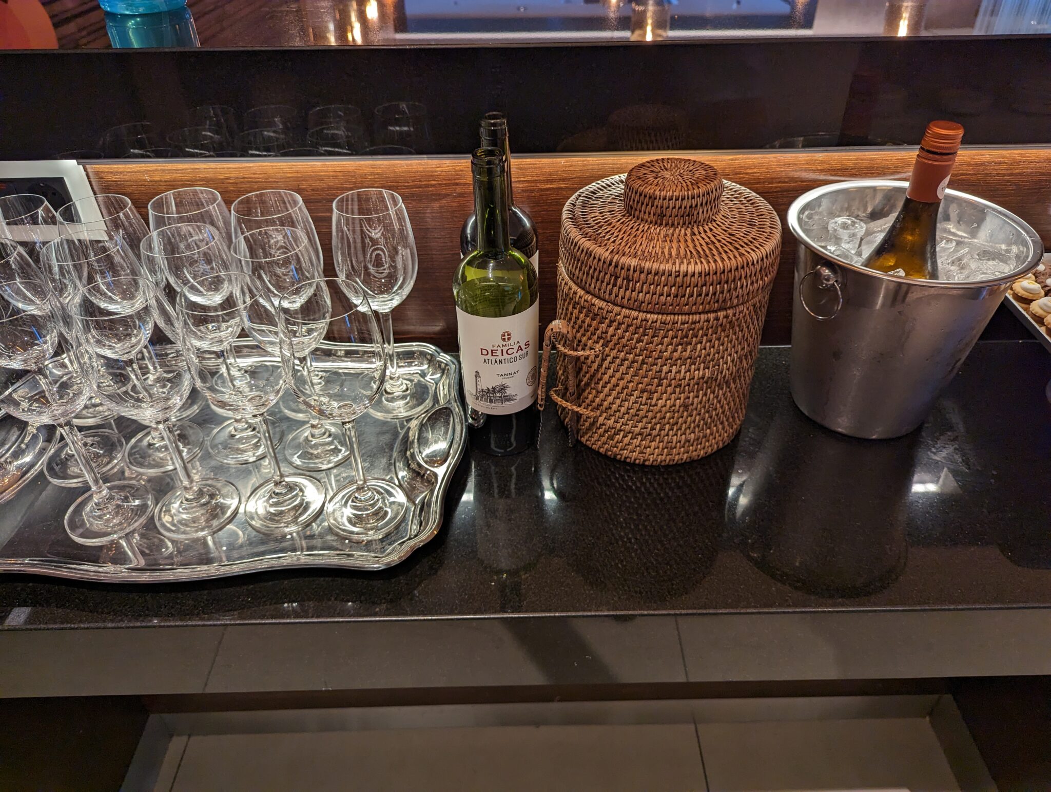 a group of wine glasses and a bottle on a counter