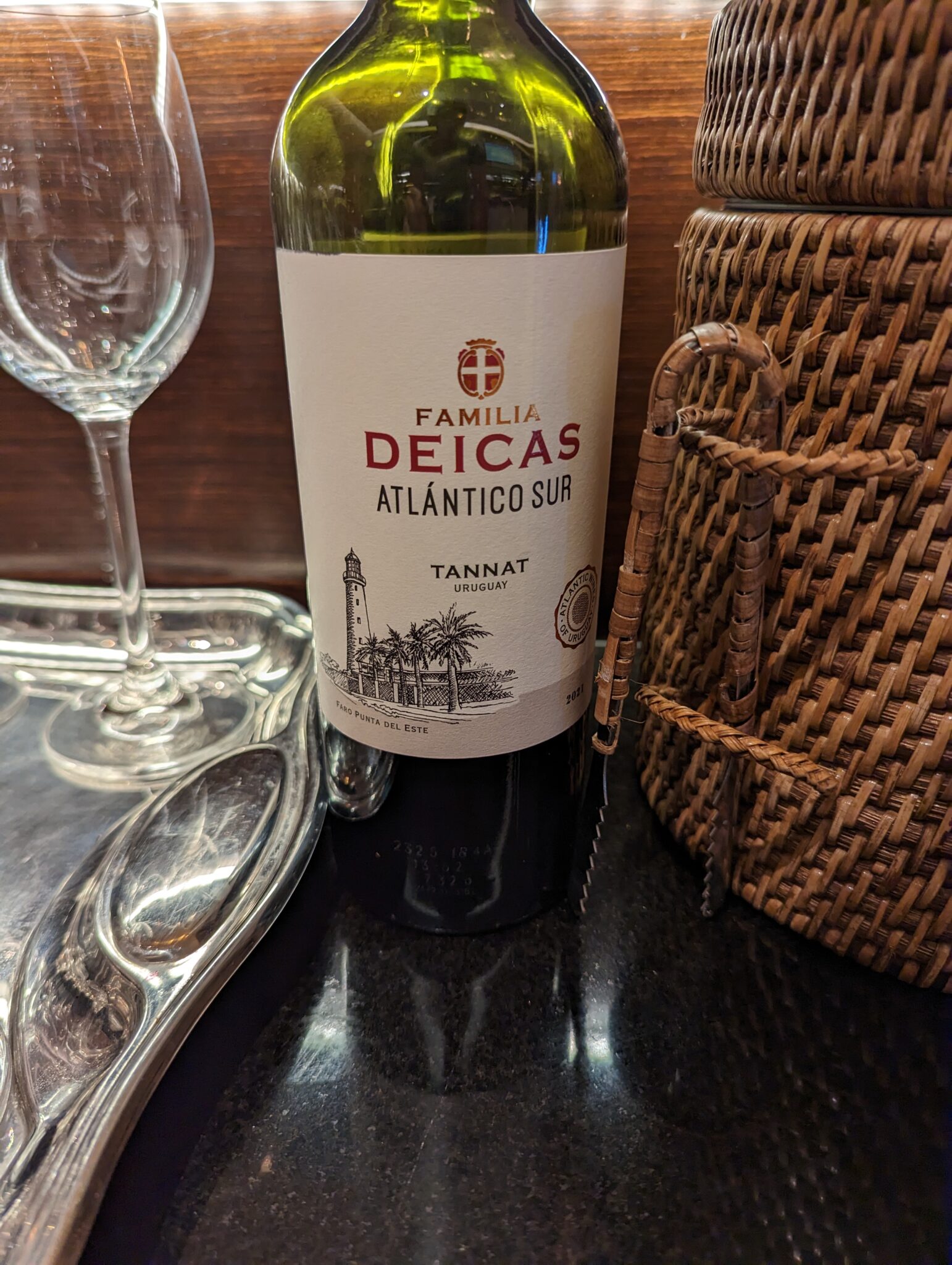 a bottle of wine next to a basket