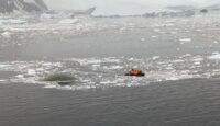 a group of people in an inflatable boat in the water