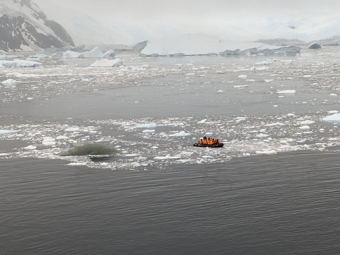 a group of people in an inflatable boat in the water