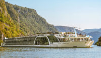 a large boat on water with a mountain in the background