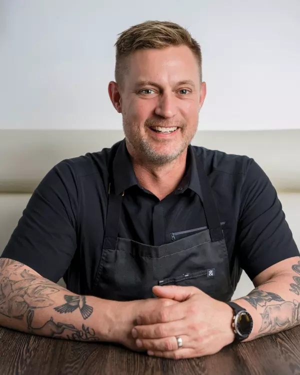 a man wearing a black shirt and black apron