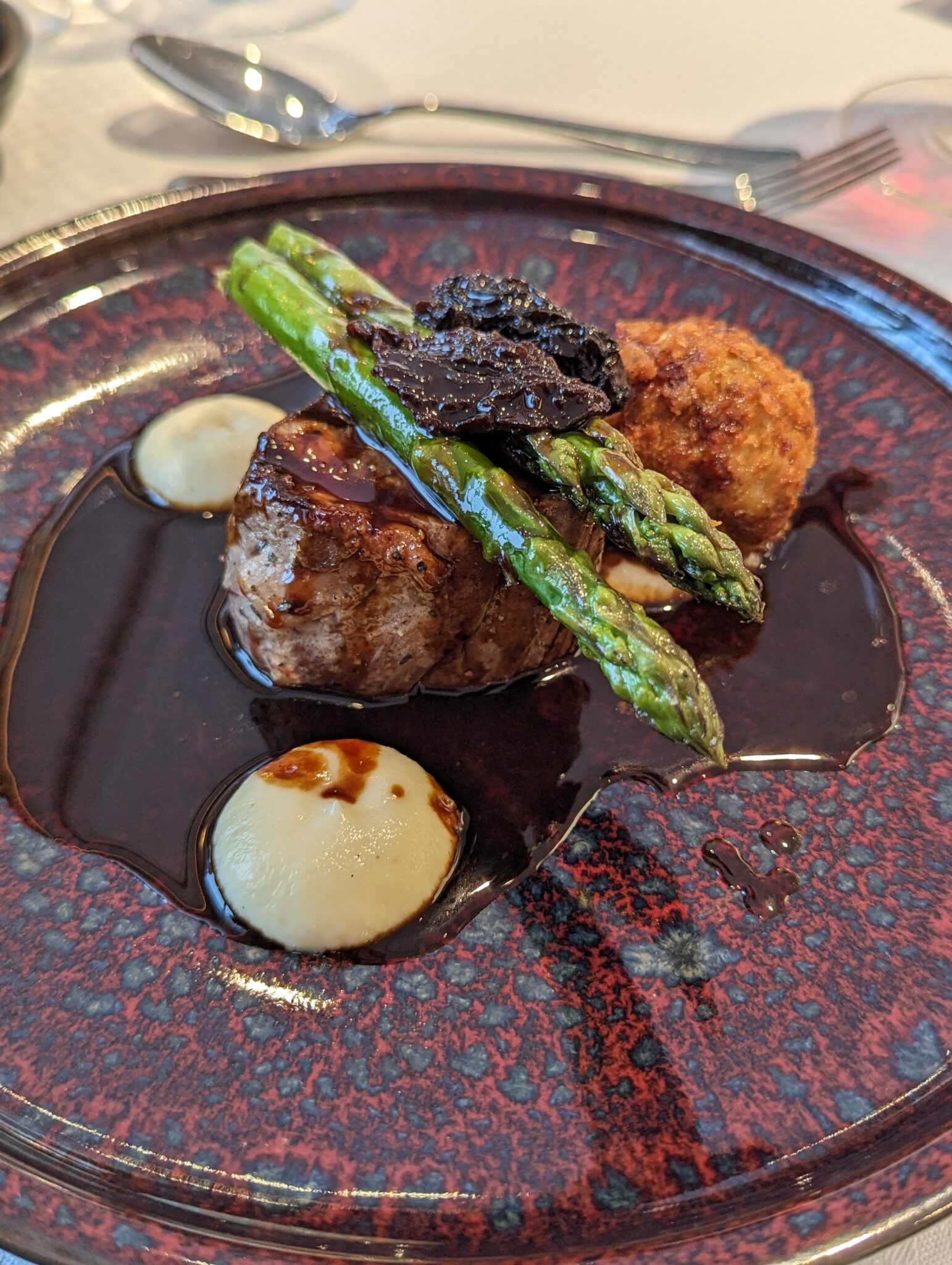 a plate of food with asparagus and mashed potatoes
