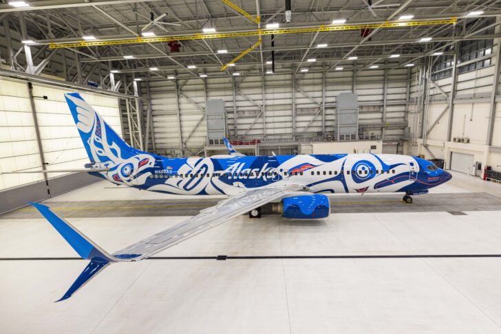 a blue and white airplane in a hangar