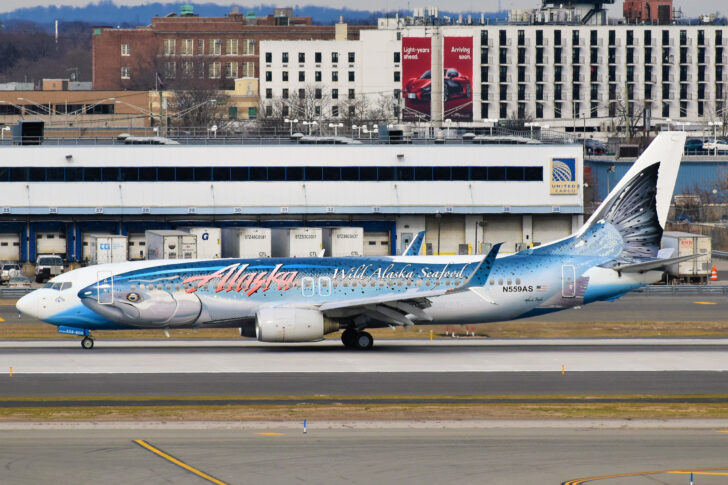 a blue airplane on a runway