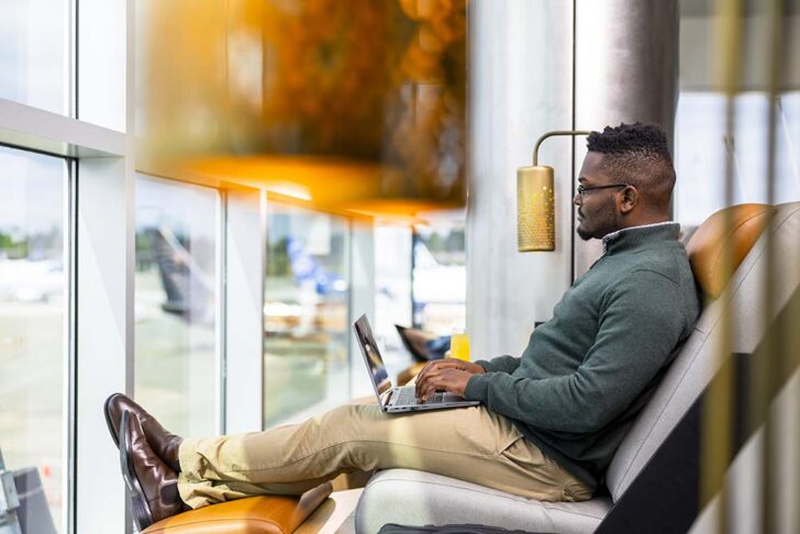 a man sitting on a couch using a laptop