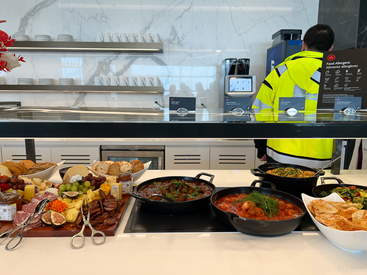 a man standing behind a counter with food on it
