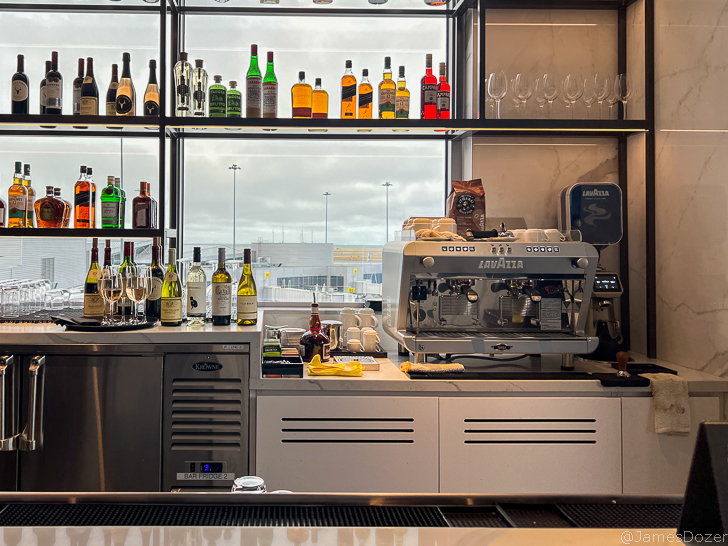a bar with a coffee machine and bottles of liquor