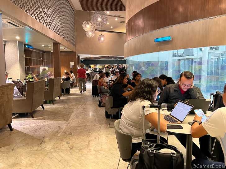 a group of people sitting at tables in a room with chairs and tables
