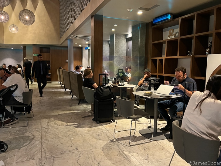 a group of people sitting at tables in a room with a man walking