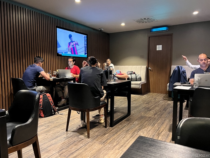 a group of people sitting around tables and a television