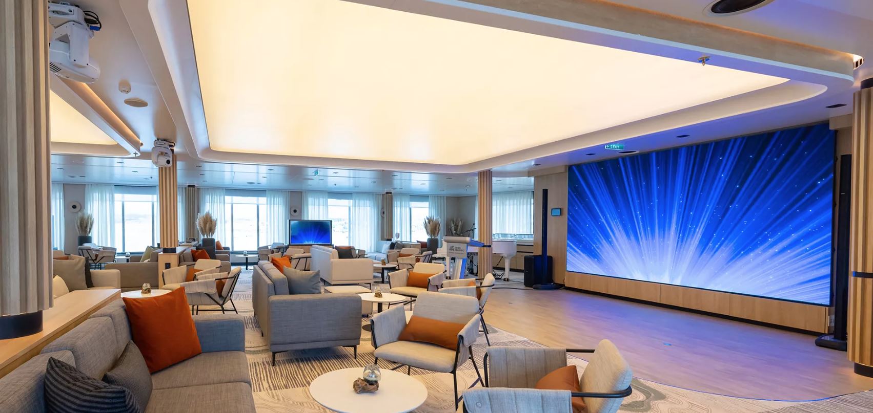 a room with a large screen and chairs