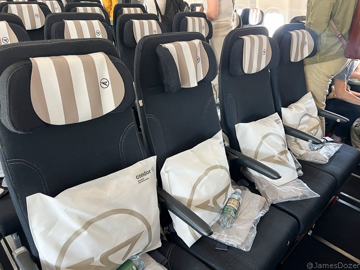 a row of seats with a white and brown striped pillow on them
