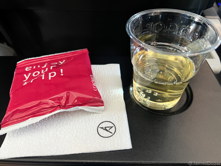 a glass of liquid and napkin on a table