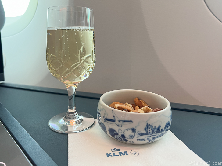 a glass of wine and a bowl of nuts