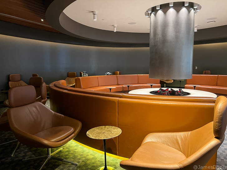 a room with a round fireplace and chairs