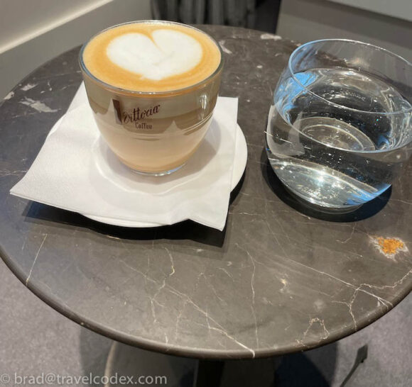 a cup of coffee and a glass of water on a table