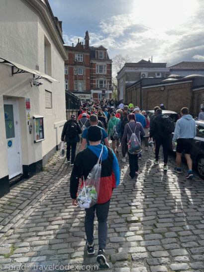 a group of people walking on a cobblestone street