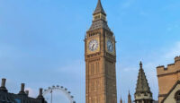 a clock tower with a ferris wheel with Big Ben in the background
