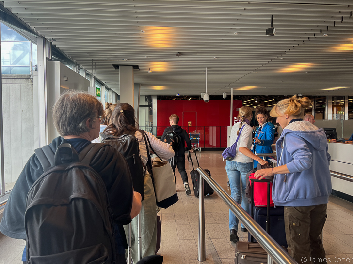a group of people standing in a line with luggage