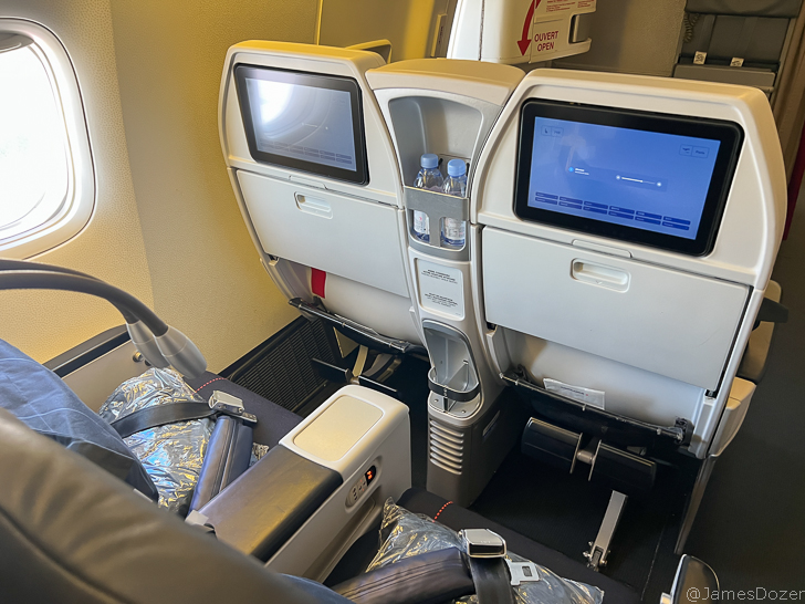 a seat with two monitors and a drink bottle in it