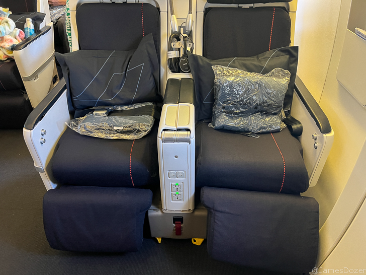 a seat with black pillows and a plastic bag on it