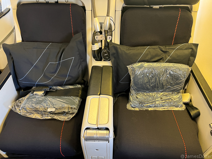 a seat with black pillows and a plastic bag on it