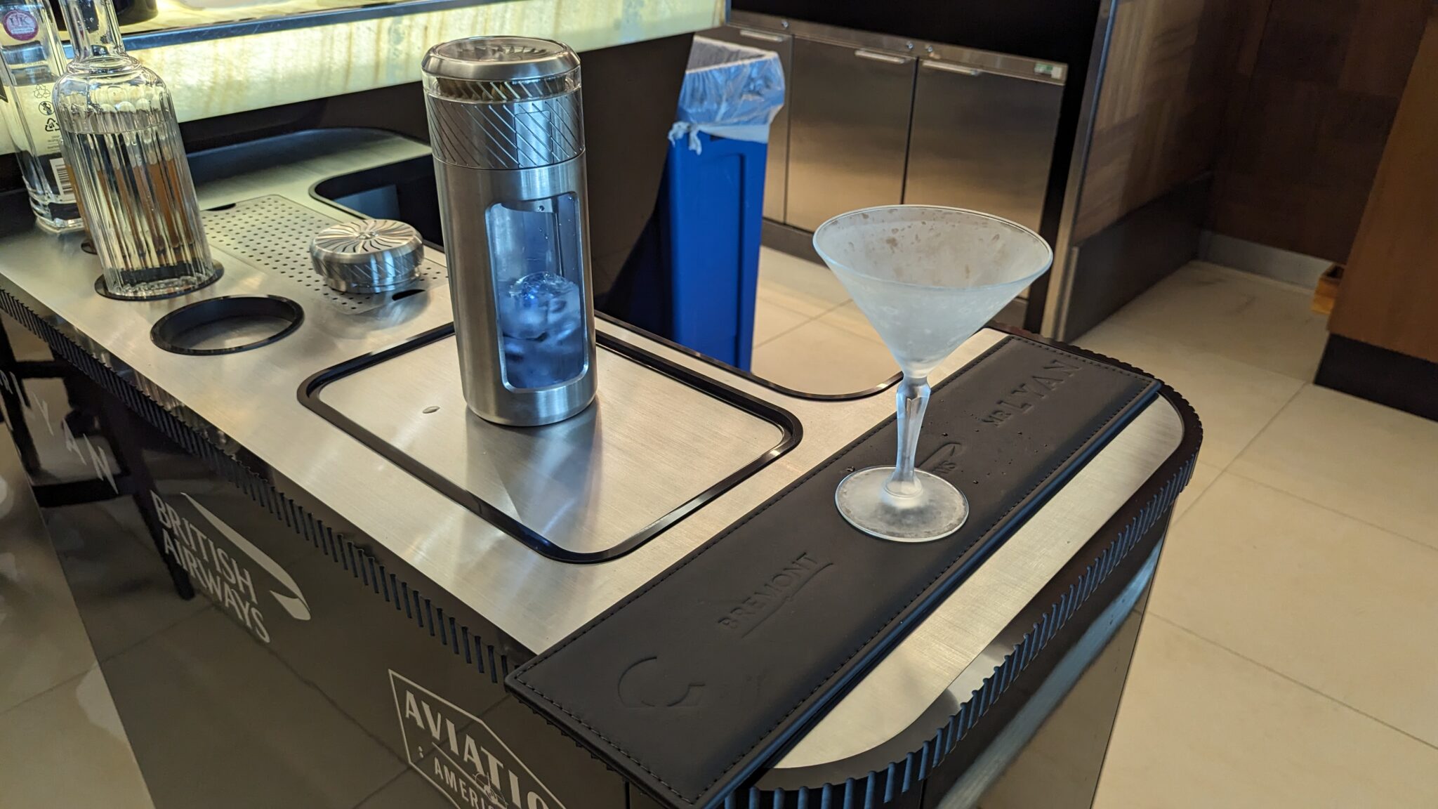 a silver and black bar with a martini glass and a silver canister