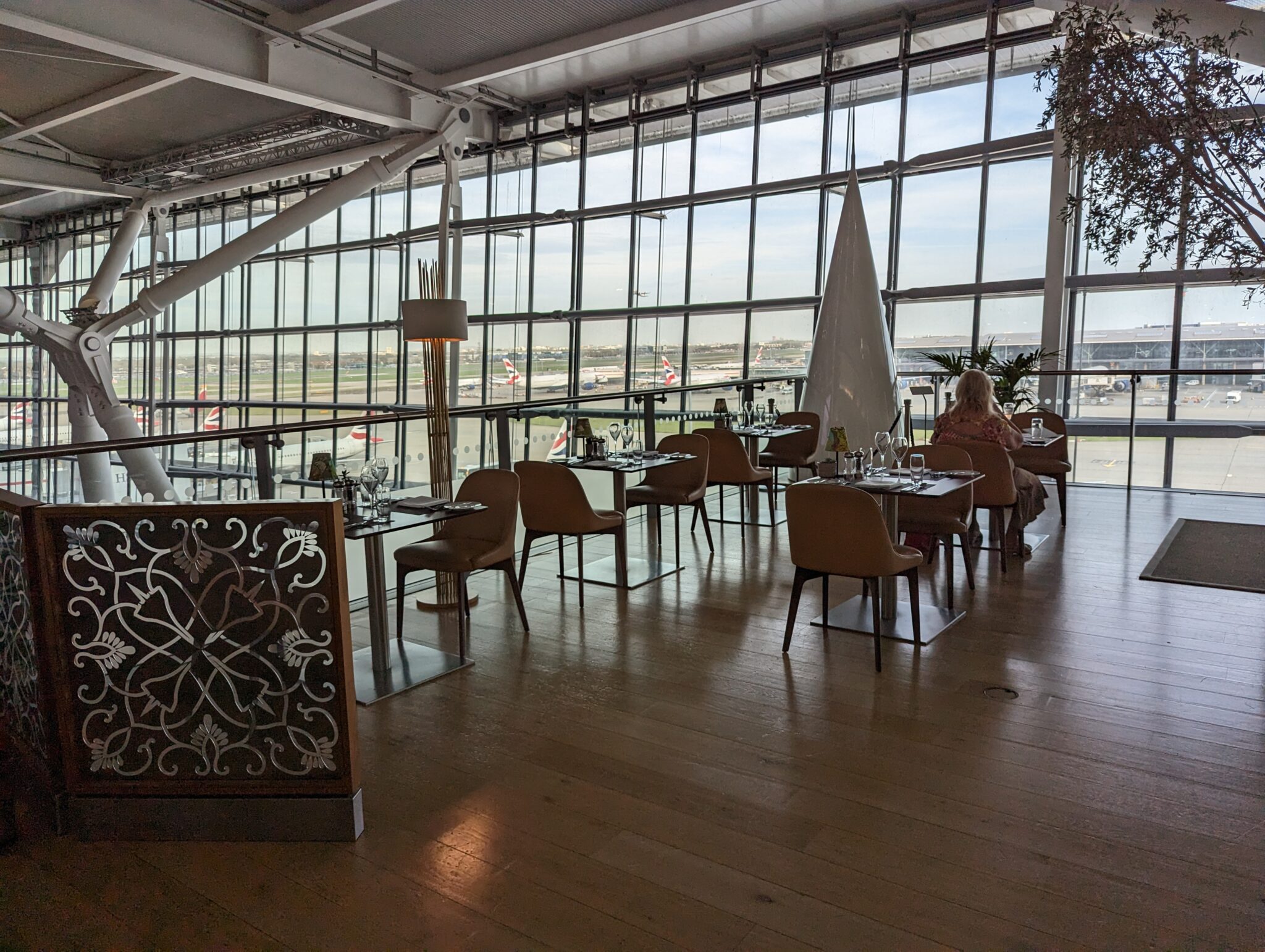 a room with tables and chairs and a large window
