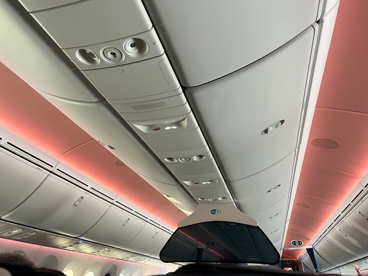 a ceiling of an airplane with lights and a mirror