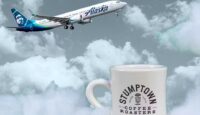 a white coffee mug with a plane flying in the air
