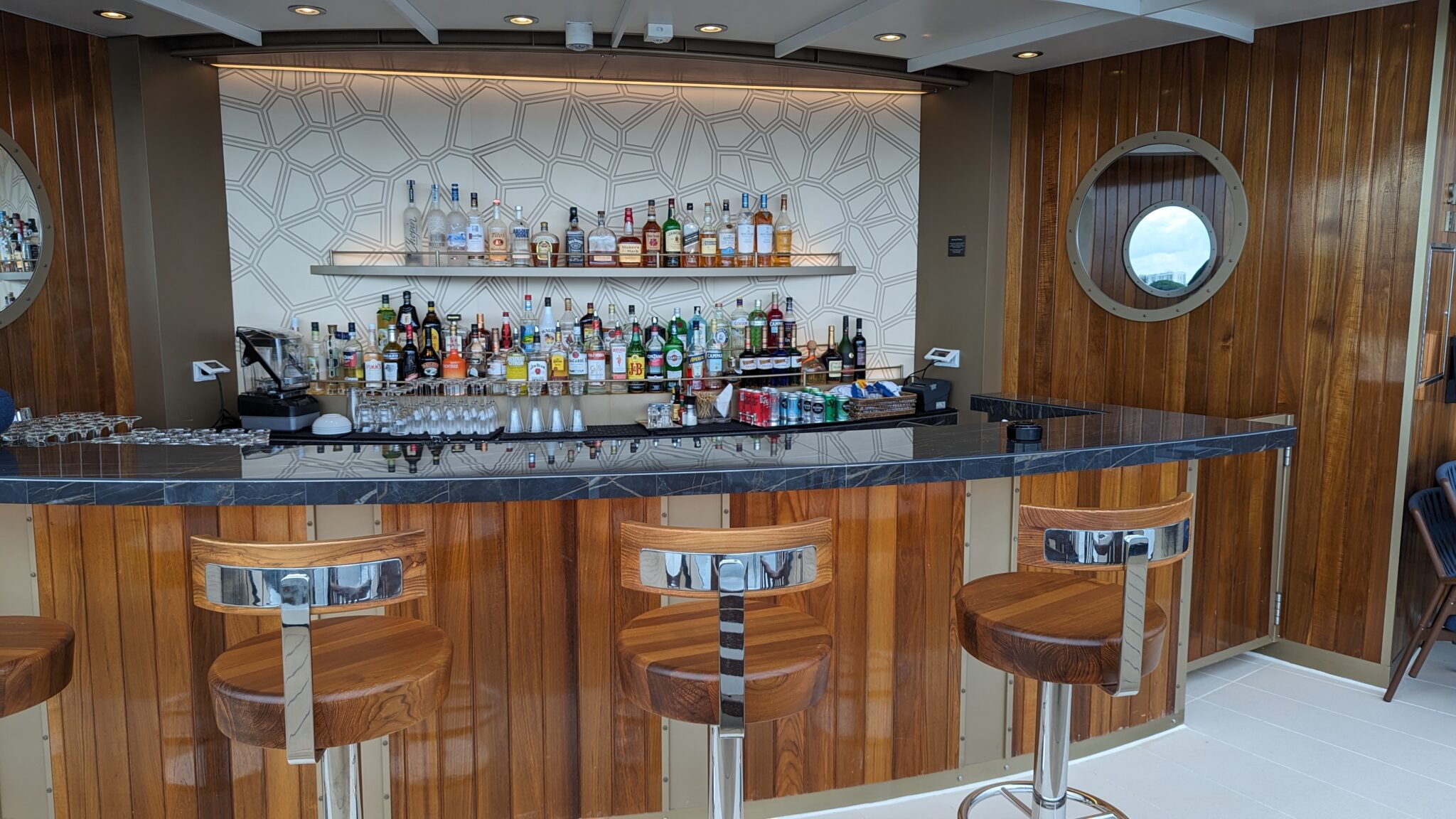 a bar with a shelf of liquor and a round mirror